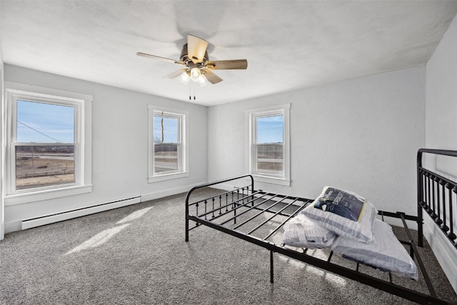 carpeted bedroom with a ceiling fan, baseboards, and a baseboard radiator