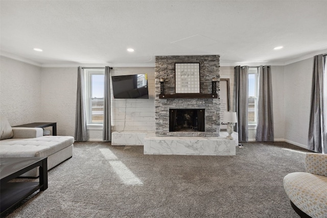 carpeted living area featuring a wealth of natural light, a fireplace, crown molding, and a textured wall