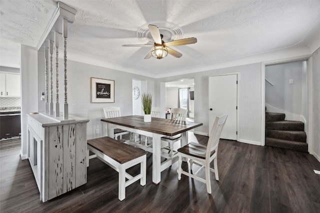 dining space featuring a ceiling fan, dark wood-type flooring, stairs, and a textured ceiling