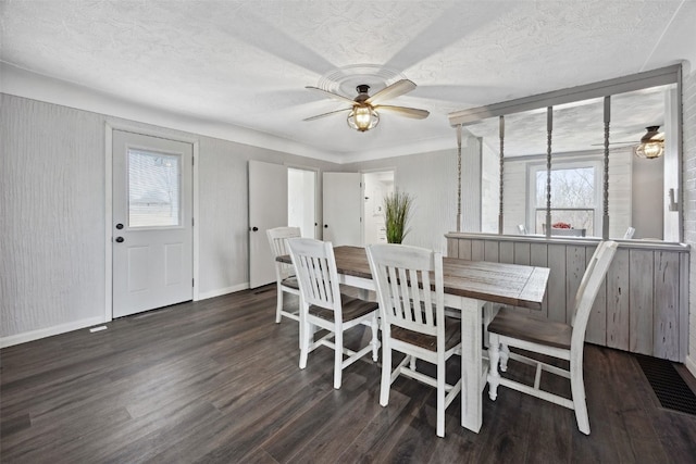 dining space featuring ceiling fan, wood finished floors, baseboards, and a textured ceiling