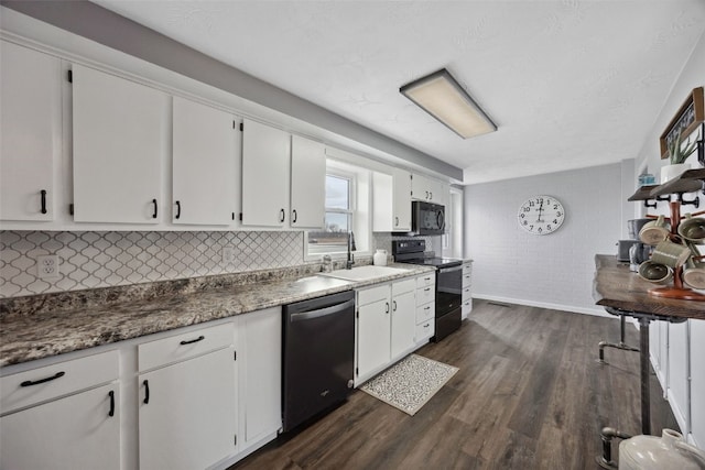 kitchen featuring white cabinetry, black appliances, dark wood-type flooring, and a sink