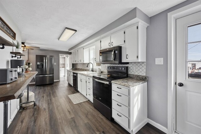 kitchen featuring black appliances, plenty of natural light, tasteful backsplash, and a sink