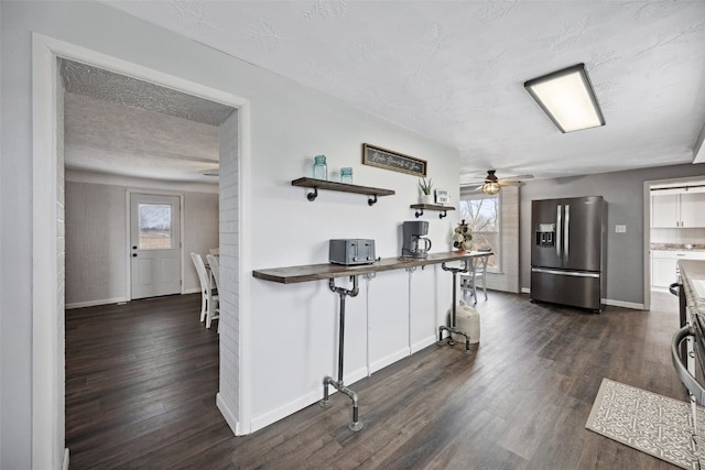 kitchen with dark wood-type flooring, a healthy amount of sunlight, and stainless steel refrigerator with ice dispenser