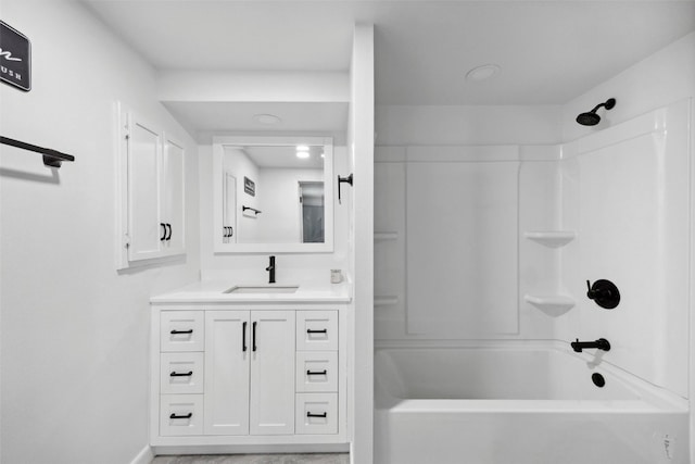 bathroom featuring tub / shower combination, baseboards, and vanity