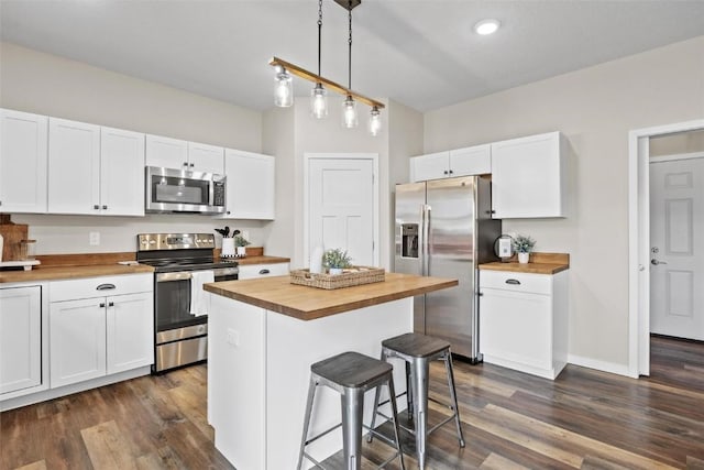 kitchen featuring butcher block countertops, white cabinets, and appliances with stainless steel finishes