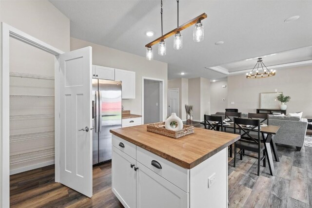 kitchen featuring dark wood finished floors, butcher block countertops, stainless steel refrigerator with ice dispenser, white cabinetry, and open floor plan