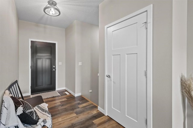 entryway featuring baseboards and dark wood-style floors