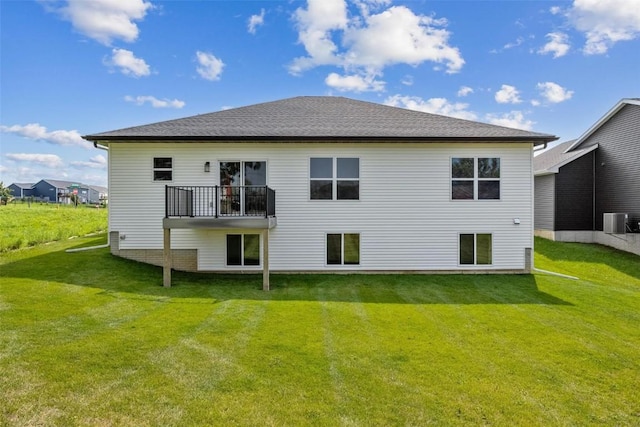 back of house featuring cooling unit, a lawn, and a shingled roof