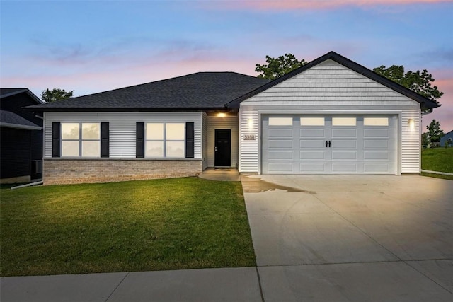 ranch-style home with a lawn, roof with shingles, concrete driveway, an attached garage, and brick siding