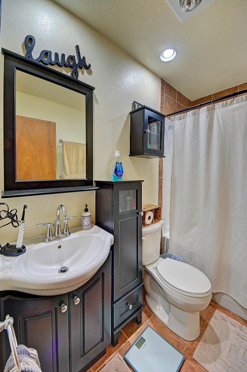 bathroom featuring vanity, a shower with curtain, tile patterned flooring, a textured ceiling, and toilet