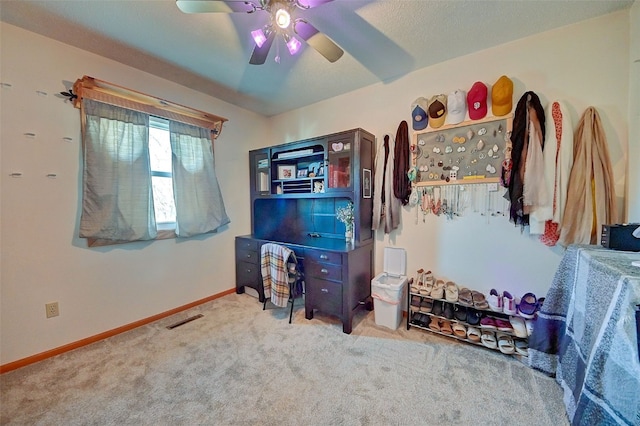 carpeted bedroom with visible vents, baseboards, and a ceiling fan