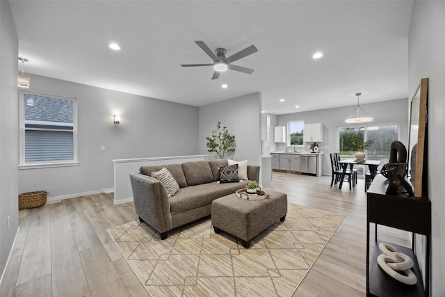 living room featuring recessed lighting, baseboards, light wood-style floors, and a ceiling fan