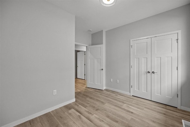 unfurnished bedroom featuring a closet, visible vents, baseboards, and light wood finished floors