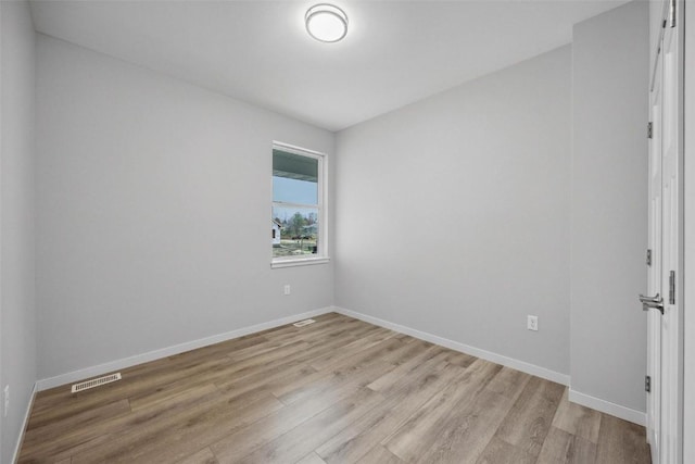 spare room with baseboards, visible vents, and light wood-type flooring