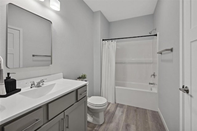 bathroom with vanity, toilet, wood finished floors, and shower / bath combo