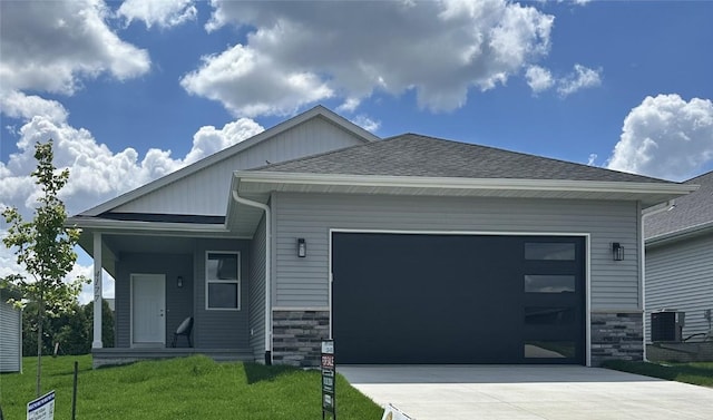 4177 Justified Dr, Marion, IA 52302 - view of front of home featuring an attached garage, concrete driveway, stone siding, and a shingled roof