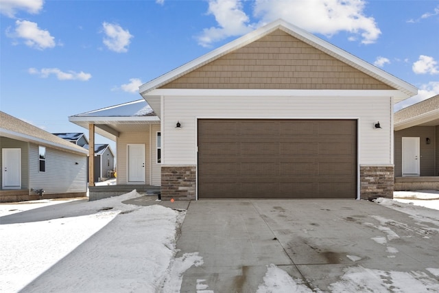 view of front of home featuring a garage, stone siding, and driveway