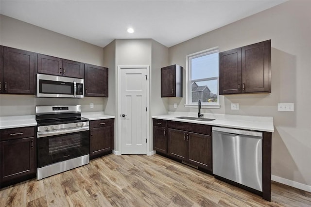 4193 Justified Dr, Marion, IA 52302 - kitchen featuring appliances with stainless steel finishes, a sink, light countertops, light wood-type flooring, and recessed lighting