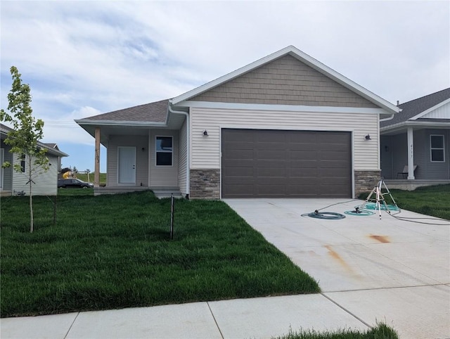 4193 Justified Dr, Marion, IA 52302 - view of front of home with driveway, stone siding, a garage, and a front yard