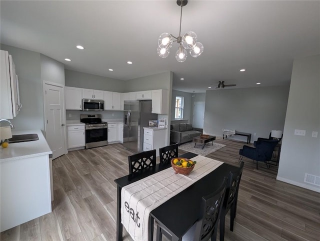 4209 Justified Dr, Marion, IA 52302 - dining area featuring a ceiling fan, light wood finished floors, a chandelier, recessed lighting, and baseboards