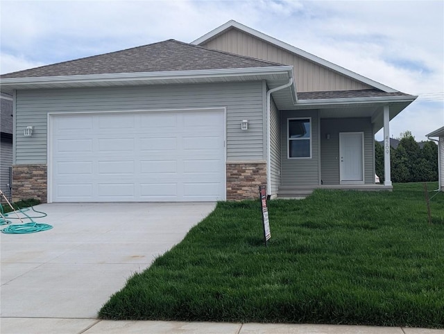 4209 Justified Dr, Marion, IA 52302 - view of front of home with stone siding, driveway, a garage, roof with shingles, and a front lawn