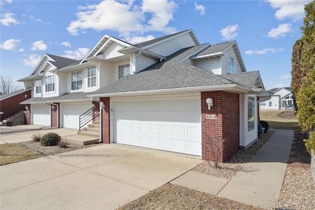 view of front of house featuring concrete driveway, a garage, brick siding, and a shingled roof