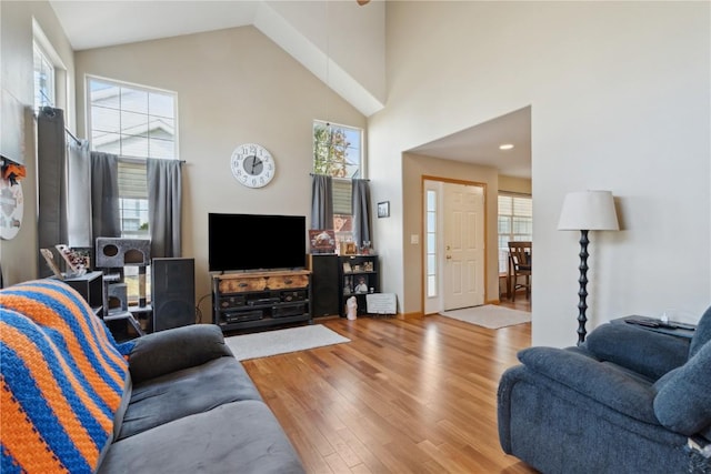 living room featuring high vaulted ceiling and wood finished floors