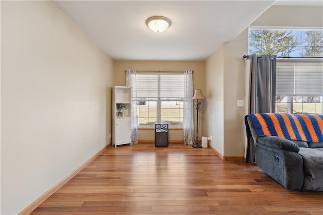 living area with light wood-type flooring and baseboards