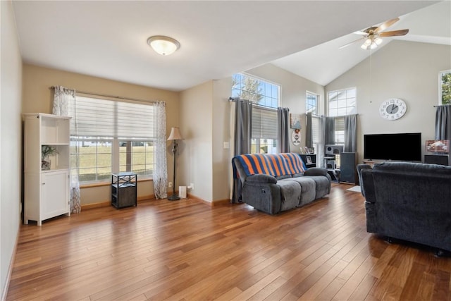 living area with high vaulted ceiling, baseboards, a ceiling fan, and wood-type flooring