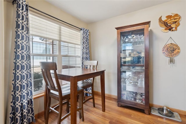 dining room with baseboards and light wood-style flooring