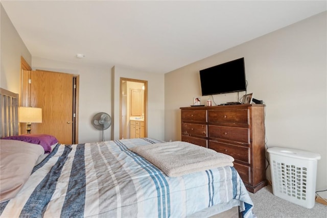 bedroom with light carpet and ensuite bathroom