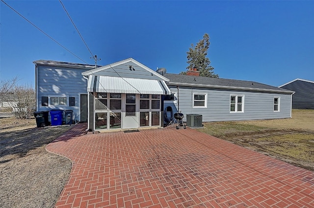 rear view of property with central AC and a chimney