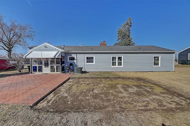 rear view of house with a patio, central AC unit, and a chimney