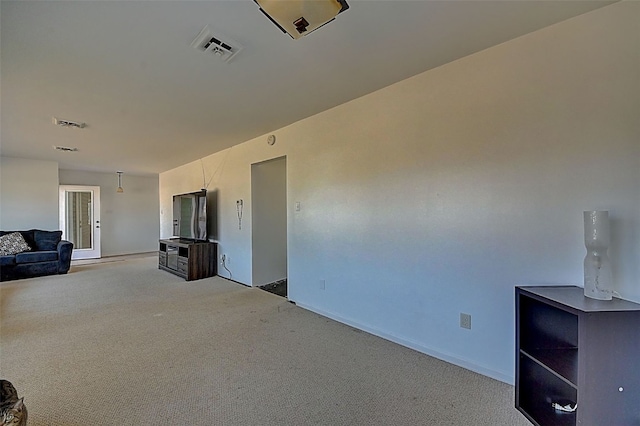 unfurnished living room featuring visible vents and light carpet