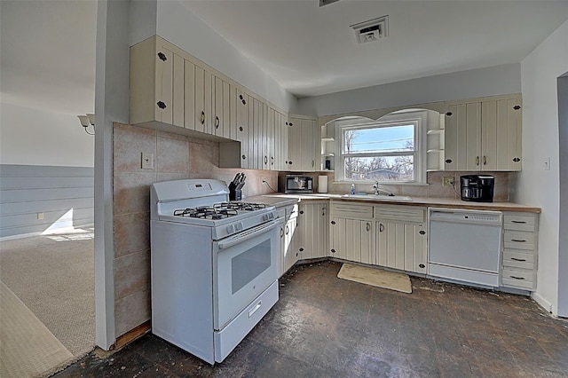 kitchen with a sink, light countertops, cream cabinetry, white appliances, and open shelves