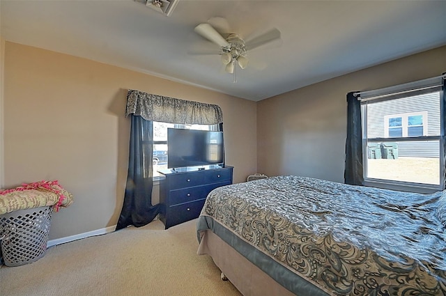 bedroom with light carpet, visible vents, multiple windows, and baseboards