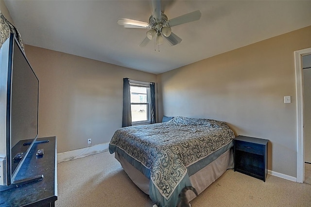 bedroom featuring light colored carpet, a ceiling fan, and baseboards