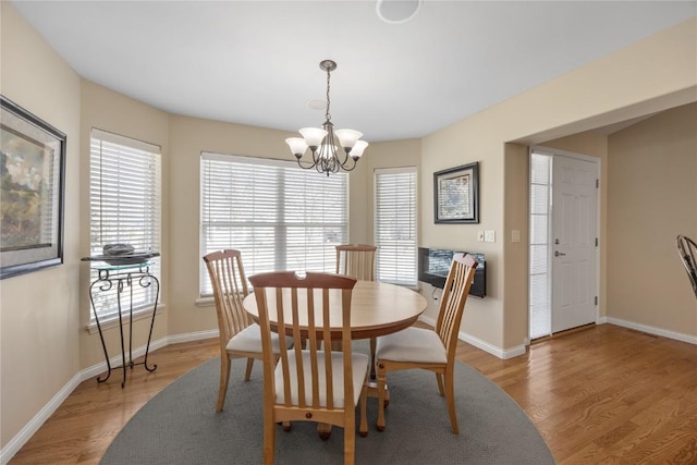 dining space featuring a chandelier, plenty of natural light, and light wood-style flooring