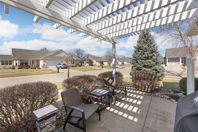 view of patio with a pergola, a residential view, and driveway