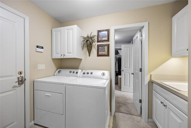 clothes washing area featuring cabinet space, light tile patterned floors, separate washer and dryer, and a sink