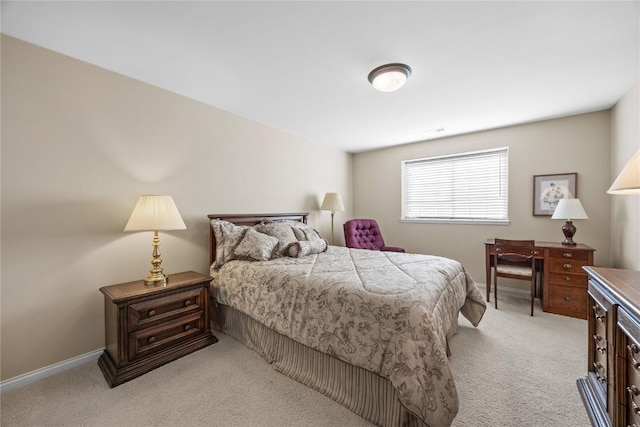 bedroom with light colored carpet and baseboards