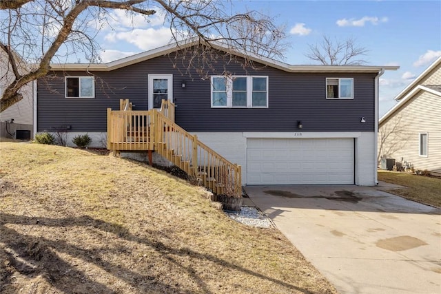 ranch-style house featuring cooling unit, an attached garage, and concrete driveway