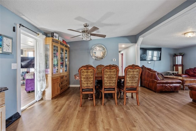 dining area with light wood-type flooring, baseboards, a textured ceiling, and a ceiling fan