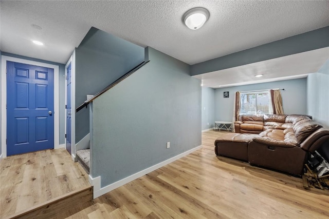 interior space featuring a textured ceiling, baseboards, and wood finished floors