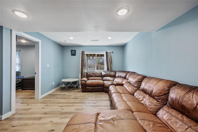 living room featuring visible vents, baseboards, recessed lighting, a textured ceiling, and light wood-type flooring