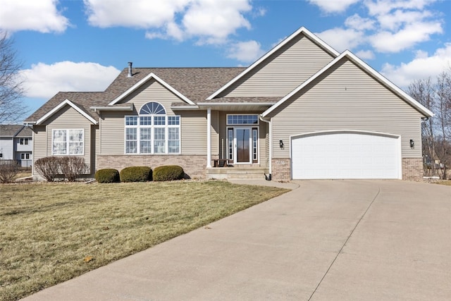 view of front of house with concrete driveway, a garage, brick siding, and a front yard