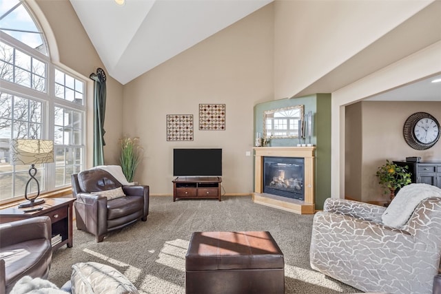 living area featuring a glass covered fireplace, high vaulted ceiling, baseboards, and carpet floors