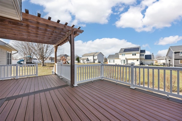 wooden terrace featuring a residential view, a lawn, and a pergola