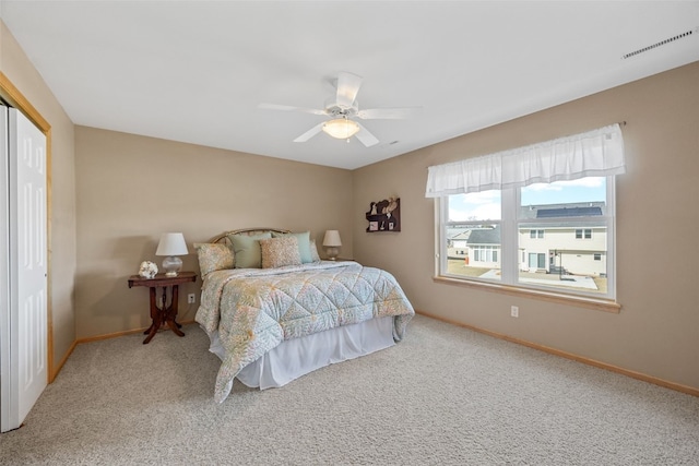 carpeted bedroom featuring visible vents, baseboards, and a ceiling fan