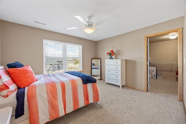 carpeted bedroom with a ceiling fan, visible vents, and baseboards